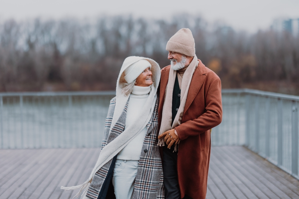 couple walking near the river, during cold winter day.