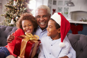 Grandfather,With,Grandchildren,Opening,Christmas,Gifts